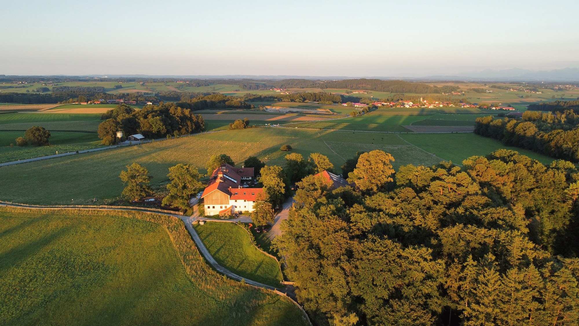 Der Hof im Abendlicht, von oben in der Landschaft.